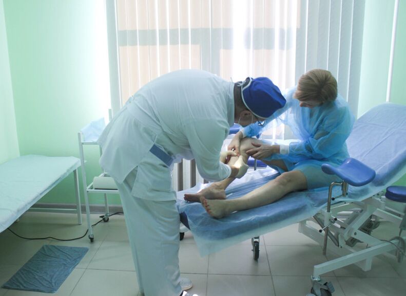 A surgeon examines a patient's veins before surgery.
